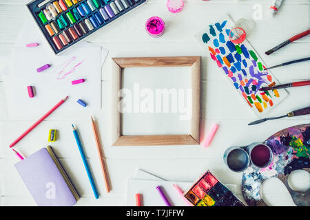 Top view Bright workplace of creative artist mockup. Blank canvas surrounded by variety of drawing supplies. Art, workshop, painting, drawing, inspira Stock Photo