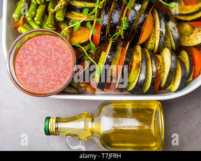 Platter of assorted fresh vegetables with red sauce- tomato and olive oil in glass bottle, Health food, fibre rich food. Ratatouille Stock Photo
