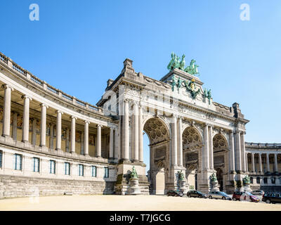 Low angle view of the arcade du Cinquantenaire, the triumphal arch in the Cinquantenaire park in Brussels, Belgium, on a sunny day against blue sky.