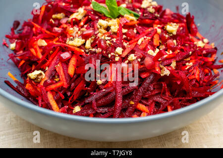 Salad of grated red beets carrots pomegranates and walnuts Stock Photo