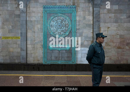 An Uzbek policeman stand guard at the Alisher Navoi Station of the Tashkent underground Metro in Uzbekistan. The Tashkent Metro built in the former USSR is one of only two subway systems currently operating in Central Asia and its stations are among the most ornate in the world. Stock Photo