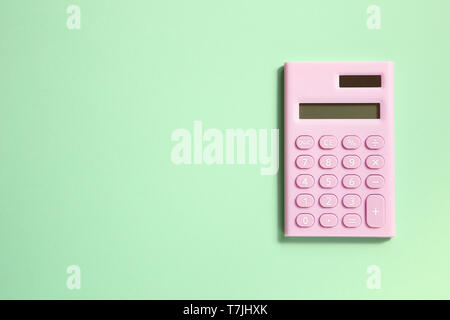 Pink digital calculator on green background Stock Photo