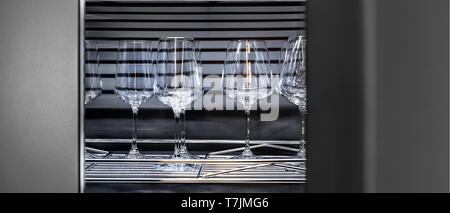 Brandy glasses and wineglasses standing on the shelf. Stock Photo