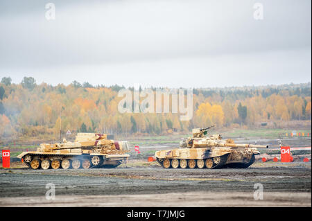 Nizhniy Tagil, Russia - September 27. 2013: Armoured recovery vehicle BREM-1M evacuates t-90S tank on exhibition range. RAE-2013 exhibition Stock Photo