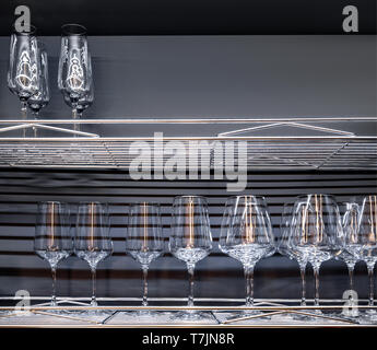Brandy glasses and wineglasses standing on the shelf. Stock Photo