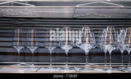 Brandy glasses and wineglasses standing on the shelf. Stock Photo