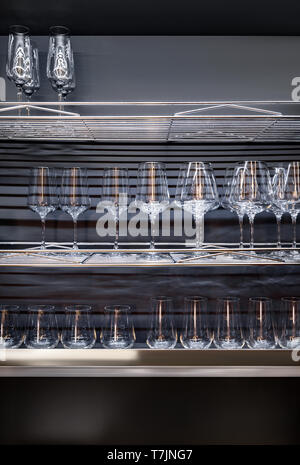 Brandy glasses and wineglasses standing on the shelf. Stock Photo