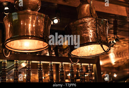 Two beautiful brass vintage lamps in a cafe with vintage wooden interior. Stock Photo