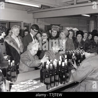 1960s, historical, a group of middel-aged ladies, many in their hats and fur coats, gather together at a drinks reception as bottles of  Scotch whisky are laid on on a counter, England, UK. Stock Photo
