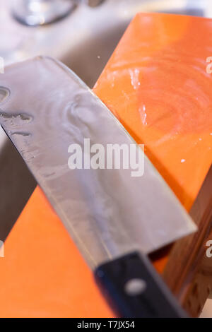 woman professional chef hands hold knife for whetting on whetstone.premium professional stone from japan.knife sharpening process with traditional sha Stock Photo