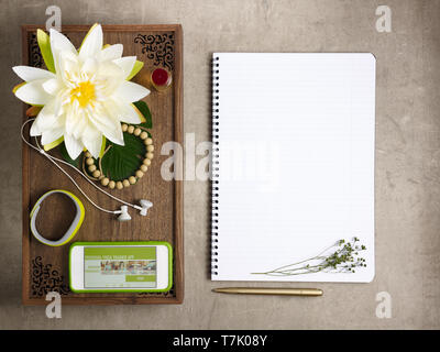 Closeup on tray with fragrant stuff for aroma yoga, beads, fitness tracker, headphones and smartphone with personal yoga trainer app and opened notebo Stock Photo
