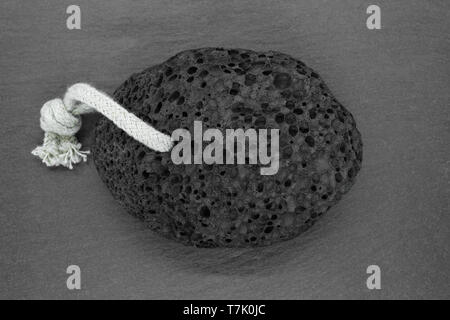 Black pumice stone with white rope for spa on grey stone background Stock Photo