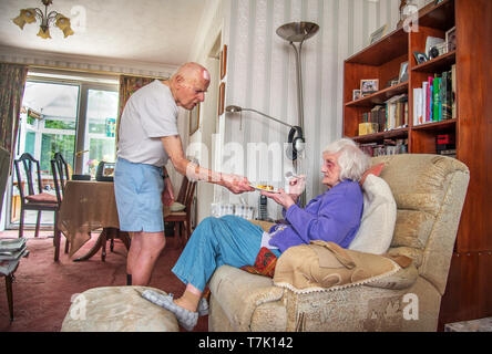 93 year old man with heart condition cares for his severely visually impaired 90 year old wife and cooks,prepaeres meals and does housework for her. Stock Photo