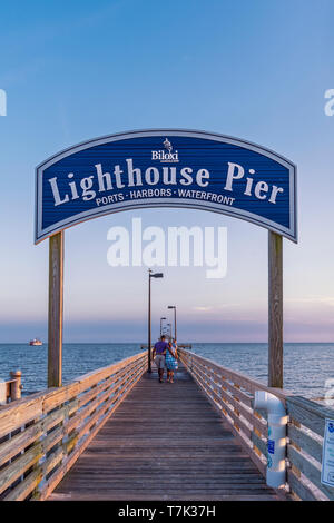 A couple walks out on Lighthouse Pier at dusk in Biloxi, Mississippi, USA. Stock Photo