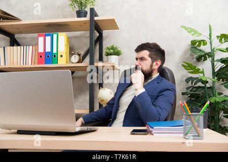 Responding on business e-mail. Brutal businessman in office. Mature man with beard work on laptop. bearded hipster use computer. Male boss working. Keeping business on top with digital technologies. Stock Photo