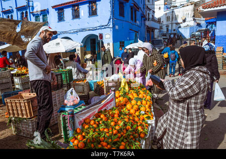 Chefchaouen, Morocco : Moroccan women shop for fruit and vegetables at Plaza Bab Suk market square, in the blue-washed medina old town. Stock Photo