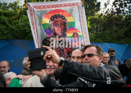 People seen taking selfies with a massive banner of Virgin Mary with her halo painted in the colours of the rainbow. Protesters gathered in the center of Warsaw to show their solidarity with Elzbieta Podlesna.  On monday Elzbieta Podlesna - a street opposition activist has been arrested on suspicion of offending religious sentiment, after posters bearing an image of the Virgin Mary with her halo painted in the colours of the rainbow flag appeared in the city of P?ock in central Poland.  The Polish interior minister, Joachim Brudzi?ski, announced on Twitter on Monday that a person had been arre Stock Photo
