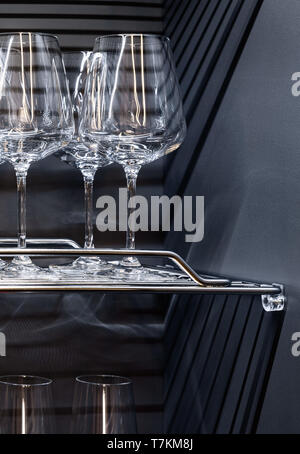 Brandy glasses and whiskey glasses standing on the shelf. Stock Photo