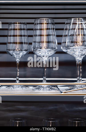 Brandy glasses and wineglasses standing on the shelf. Stock Photo