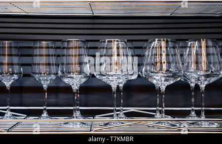 Brandy glasses and wineglasses standing on the shelf. Stock Photo