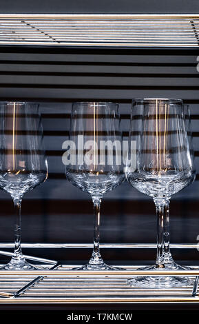 Brandy glasses and wineglasses standing on the shelf. Stock Photo