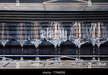 Brandy glasses and wineglasses standing on the shelf. Stock Photo