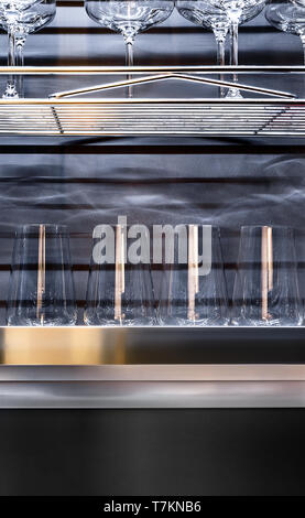 Brandy glasses and wineglasses standing on the shelf. Stock Photo