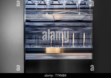 Brandy glasses and wineglasses standing on the shelf. Stock Photo