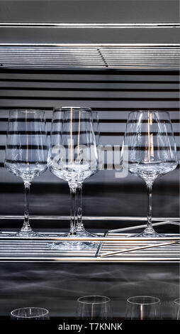 Brandy glasses and wineglasses standing on the shelf. Stock Photo