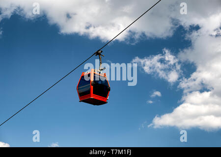 Single red cable car on cableway isolated on blue sky, overhead cableway car of Pohorska vzpenjaca in Maribor, Slovenia Stock Photo