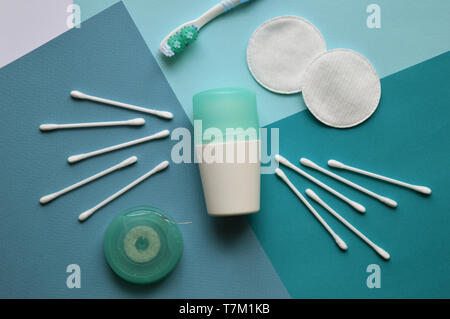 A deodorant, cotton pads for face and buds for ears, brushtooth and dental floss on blue background of different tones. Stock Photo