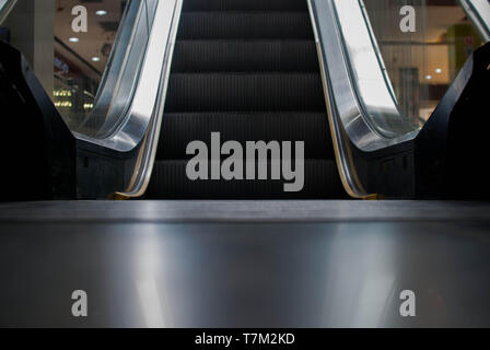 Escalator in Community Mall, Shopping Center. Moving up staircase. electric escalator. Close up to escalators. Close up floor platform. yellow bands.  Stock Photo