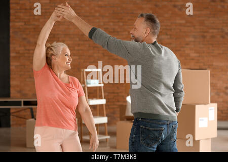 Happy mature couple dancing indoors. Moving into new house Stock Photo