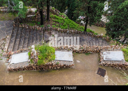 Aerial view of stone stairs and several graves with gravestones on the Montjuic Cemetery, Barcelona, Catalonia, Spain