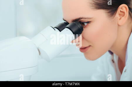 Scientist using microscope in lab, close-up. Laboratory technician while work Stock Photo
