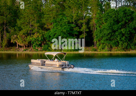 Orlando, Florida. April 02, 2019.  Bay boat at blue lake on green forest background at Walt Disney World  (1) Stock Photo