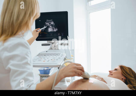 Pregnant woman having sonogram at clinic. pregnant patient ultrasound exam Stock Photo