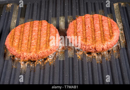 Close up of plant based burger patties on griddle being grilled Stock Photo