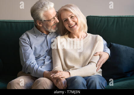 Head shot portrait of aged loving husband embracing smiling wife Stock Photo
