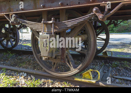 Wheels old steam locomotive on rails with brake in foreground is grass. Stock Photo