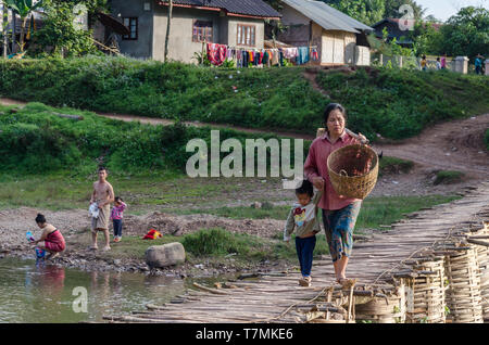 A woman and her child crossing a bridge in Luang Namtha, Laos Stock Photo