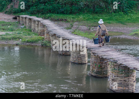 A woman crossing a bridge in Luang Namtha, Laos Stock Photo