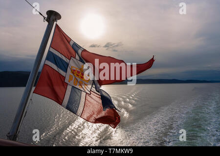 Flag of Norwegian Postal Services, as flown from the stern of Hurtigruten ship 'MS Spitsbergen', Trondheimsfjorden, Trøndelag, Norway Stock Photo