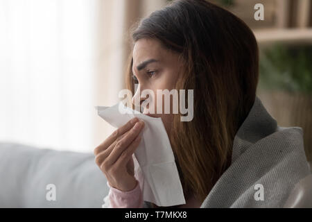 Side view close up woman holding paper tissue sneezing Stock Photo