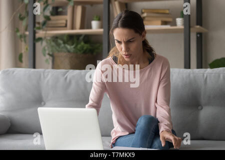 Frown woman looking on computer screen received bad news Stock Photo