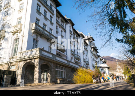 Sinaia, Romania - March 09, 2019: People enjoy an walk in Sinaia's central Park alleys along side Palace Hotel in Prahova county, Romania. Stock Photo