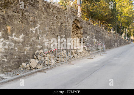 damaged exterior reinforcement wall - danger on the road Stock Photo