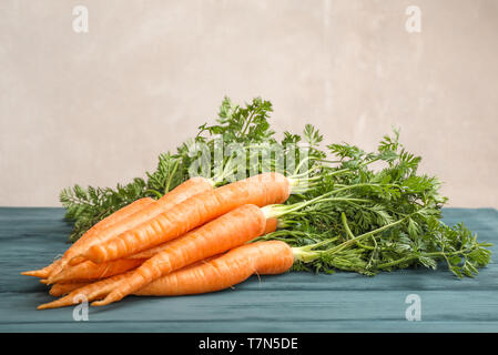 Ripe carrots on wooden table against light background, space for text Stock Photo