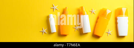 Flat lay composition with sunscreen sprays and starfishes on color background, space for text. Summer vacation backdrop Stock Photo
