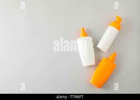 Flat lay composition with sunscreen sprays on grey background. Space for text, top view Stock Photo